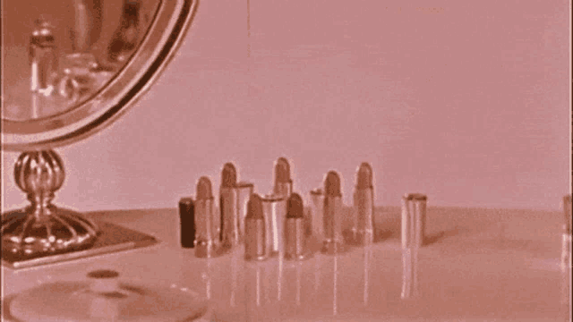 a row of lipsticks are lined up on a table in front of a mirror