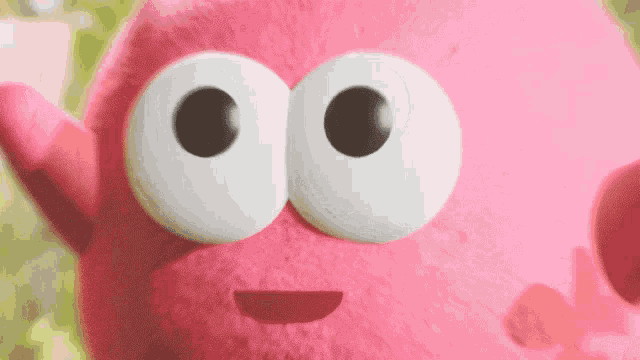 a pink cartoon character with big white eyes and a smile