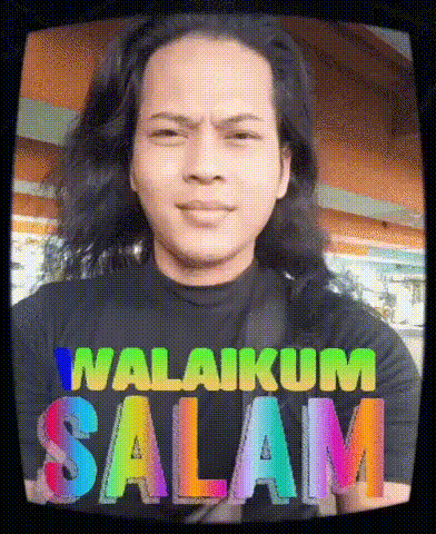 a man with long hair is wearing a t-shirt that says ' malingum salam ' on it .