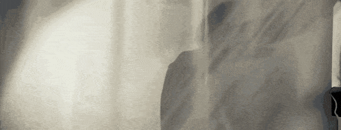 a shadow of a person is cast on a wall in a room .