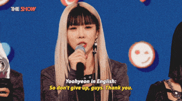 a woman singing into a microphone with the words " yoohyeon in english so don 't give up guys thank you "