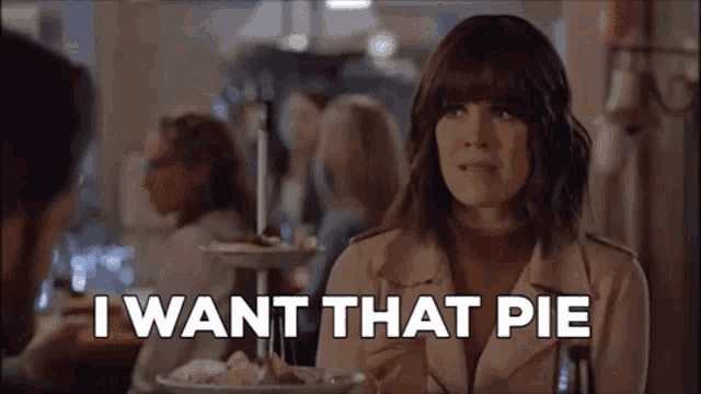 a woman is sitting at a table with a plate of food and the words `` i want that pie '' written above her .