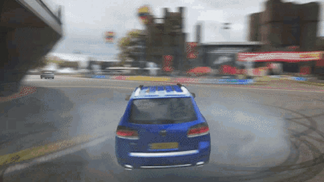 a blue car with a license plate that says ' aa ' on it is driving down a road