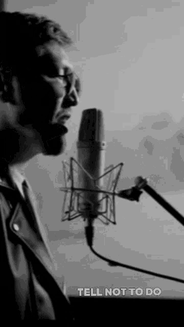 a black and white photo of a man singing into a microphone with the caption tell not to do