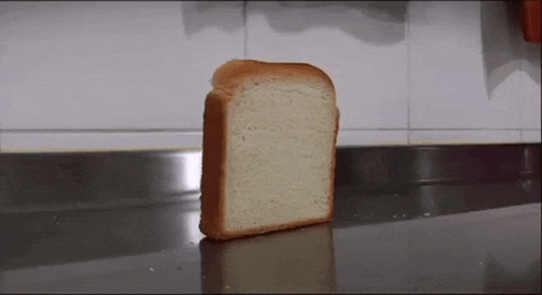 a slice of bread is sitting on a counter in front of a wall .