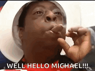 a man is making a funny face and saying `` well hello michael ! ''