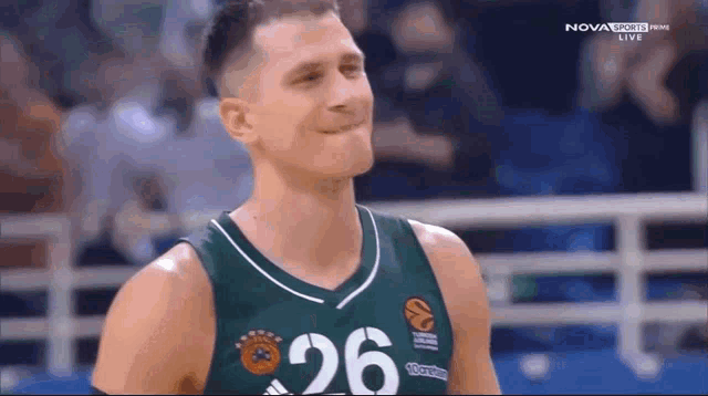 a basketball player wearing a green and white jersey with the number 26 on it