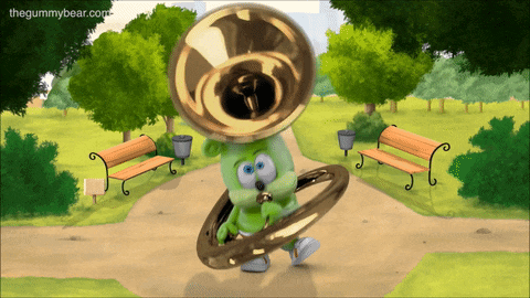 a gummy bear plays a tuba in a park