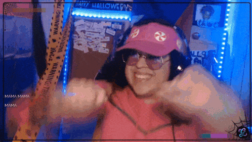 a woman wearing a pink hat and sunglasses is smiling in front of a sign that says " happy halloween "