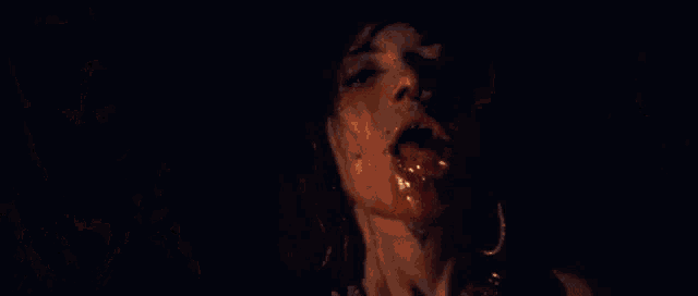 a woman is dancing in front of a large fire in the dark .