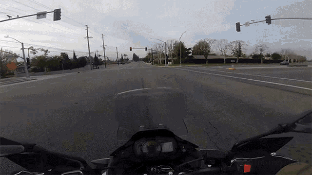 a person is riding a motorcycle down a street with a red light on the right