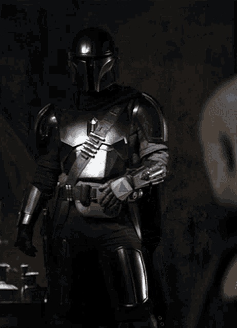 a man in armor is standing in the dark