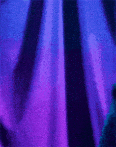a person standing in front of a purple curtain
