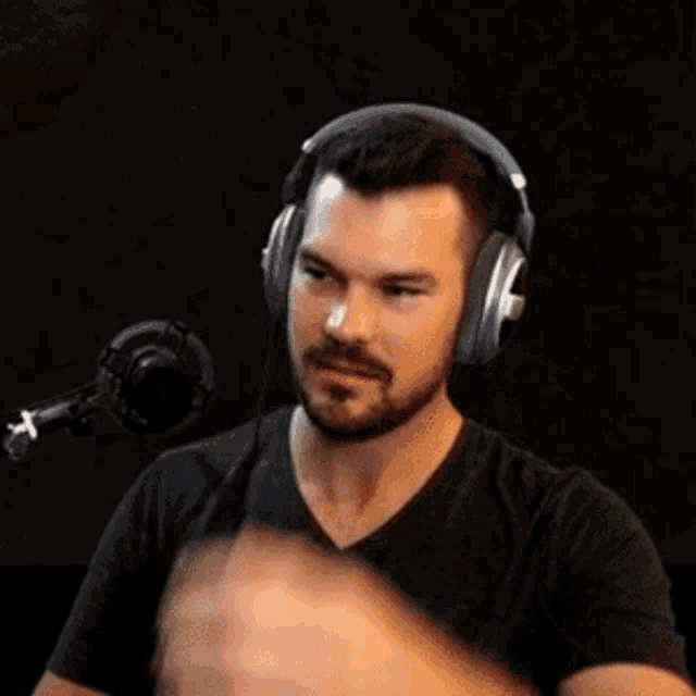 a man with a beard wearing headphones and a black shirt