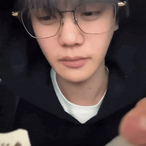 a close up of a person wearing glasses and a white t-shirt