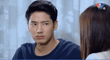 a man in a black shirt is looking at a woman in a white shirt