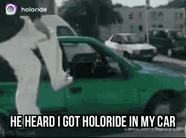 a man is standing in front of a green car and says he heard i got holoride in my car