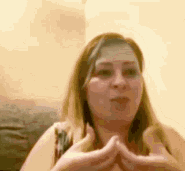 a woman is sitting on a couch making a funny face .