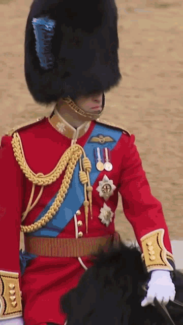 a man in a red uniform with gold trim is riding a horse