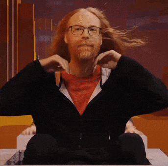 a man with long red hair and a beard is sitting in a box