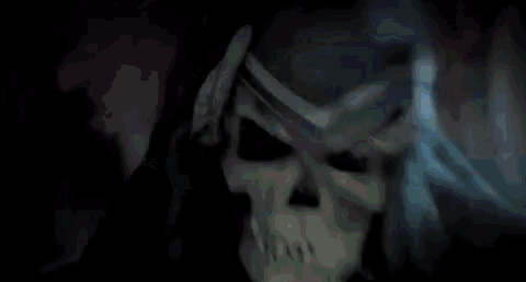 a skeleton is playing a guitar in a dark room .