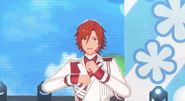a man with red hair and green eyes is standing in front of a blue background with flowers .