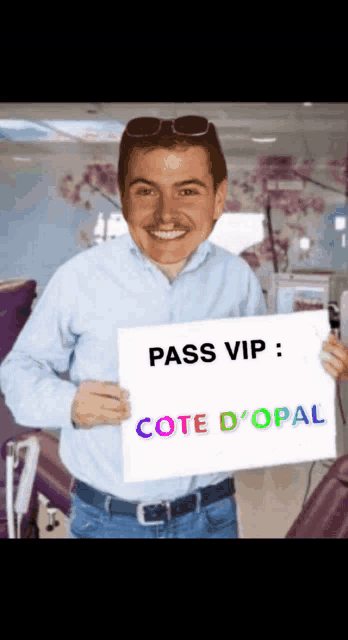 a man in a blue shirt is holding a sign that says pass vip cote d' opal