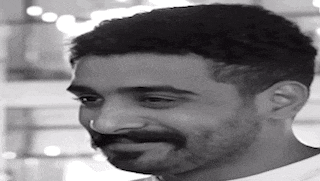 a black and white photo of a man with a beard and nose ring