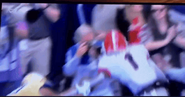 a blurry picture of a football game with the number 1 on the back