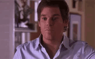 a close up of a man 's face in a blue shirt .