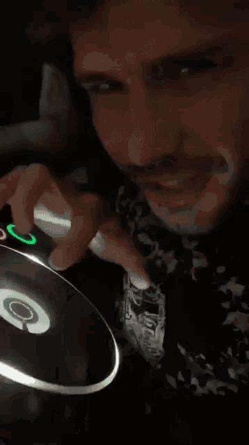 a man with a mustache is pressing a button with a green circle on it
