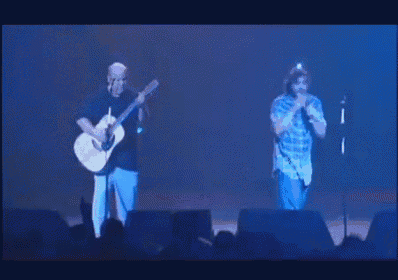 a man playing a guitar and a man singing into a microphone