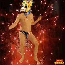 a shirtless man with a mask on his head is dancing in front of fireworks