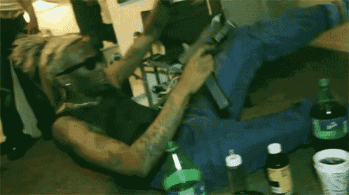a man is laying on the floor with a bottle of water in front of him .
