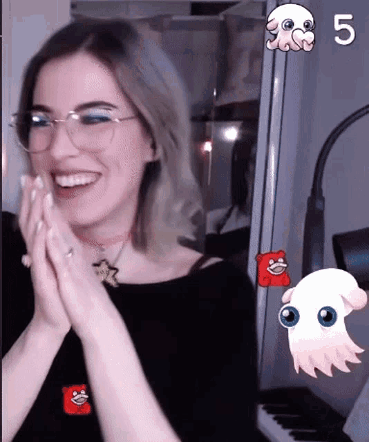a woman wearing glasses is smiling in front of a keyboard with the number 5 visible