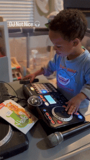 a little boy is playing a dj set with the words dj not nice visible