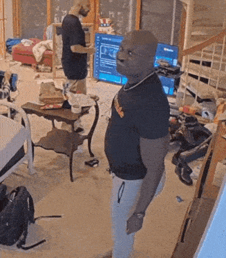 a man wearing a black shirt that says youtube stands in a living room