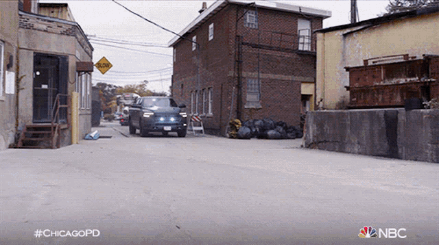 a car is driving down a street with a nbc logo in the corner