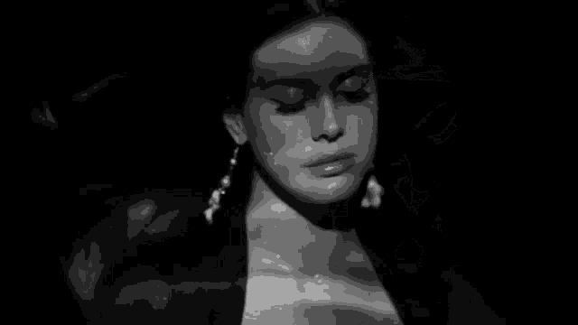 a close up of a woman 's face in a black and white photo