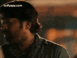 a man with a beard and mustache is making a funny face in a blurry photo .