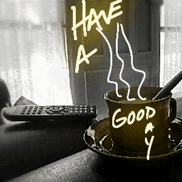 a cup of coffee with a spoon in it that says have a good day