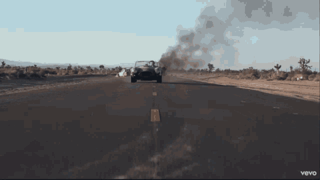 a car is driving down a desert road with smoke coming out of its exhaust pipe