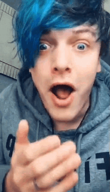 a young man with blue hair is wearing a hoodie with the letter a on it
