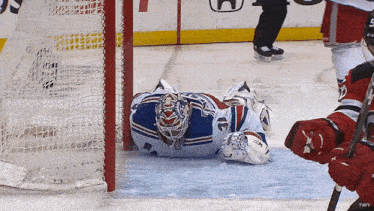 a hockey goalie is laying on the ice with a ccm glove on