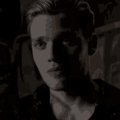 a close up of a man 's face in a dark room smiling .