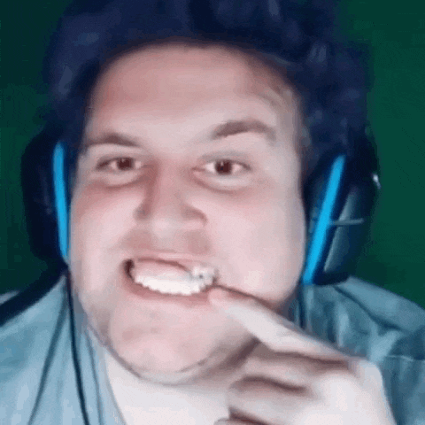 a man wearing headphones is pointing to his teeth .