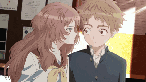 a girl kisses a boy on the cheek in front of a bulletin board with chinese writing