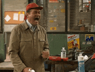 a man wearing a red hat screams in front of a michelin poster