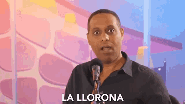 a man speaking into a microphone with la llorona written on the bottom of his face