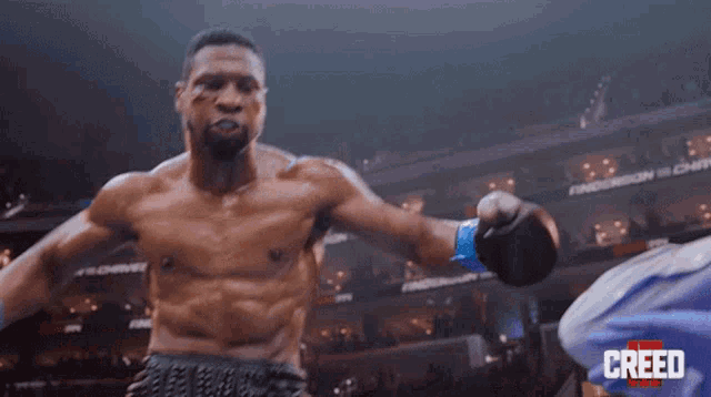 a man in a boxing ring with the word creed in the background